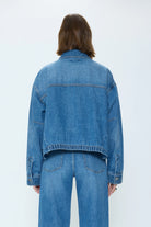 Medium blue denim jacket, back view, with a relaxed fit and an elasticated bottom hem.