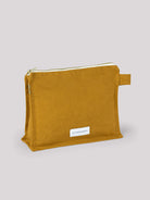 Golden-yellow rectangular cotton toiletry bag with a gold zipper, white zipper tape, and a side fabric loop.