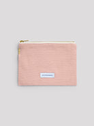 Light pink cotton pouch with a gold zipper and a small blue "LES PENSIONNAIRES" label centered on the front.