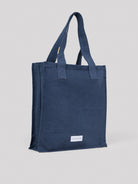 Dark blue cotton tote bag with two top handles. Features a white rectangular "LES PENSIONNAIRES" label on the front.