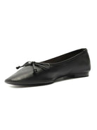 Classic black leather flats offer a pointed toe silhouette and are finished with a delicate self-tie bow detail.