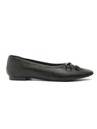Black leather ballet flats feature a pointed toe and a small decorative bow detail on the front.