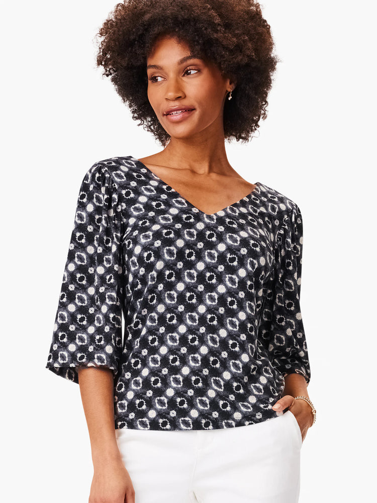 Black top with a V-neck and 3/4 sleeves.  Features a repeating pattern of light gray and dark gray/black shibori-style...