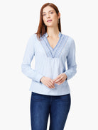 Light blue long-sleeve top with V-neck and blue/gray embroidery detail.