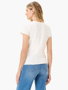 Off-white lace-knit t-shirt with short, scalloped sleeves.  The shirt has a textured appearance.