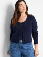 Navy ribbed knit cardigan with a V-neck, long sleeves, and a single gold-toned butterfly clasp at the chest.