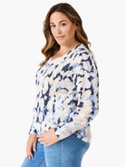 Off-white sweater with blue, light-blue, and beige abstract print. Long sleeves, v-neck.