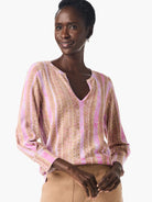 Pink and beige striped V-neck sweater with long sleeves.