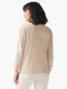 Beige cardigan, long sleeves. White and gold floral embroidery on sleeves.