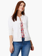 Off-white cardigan with gold buttons, front pockets, and long sleeves.
