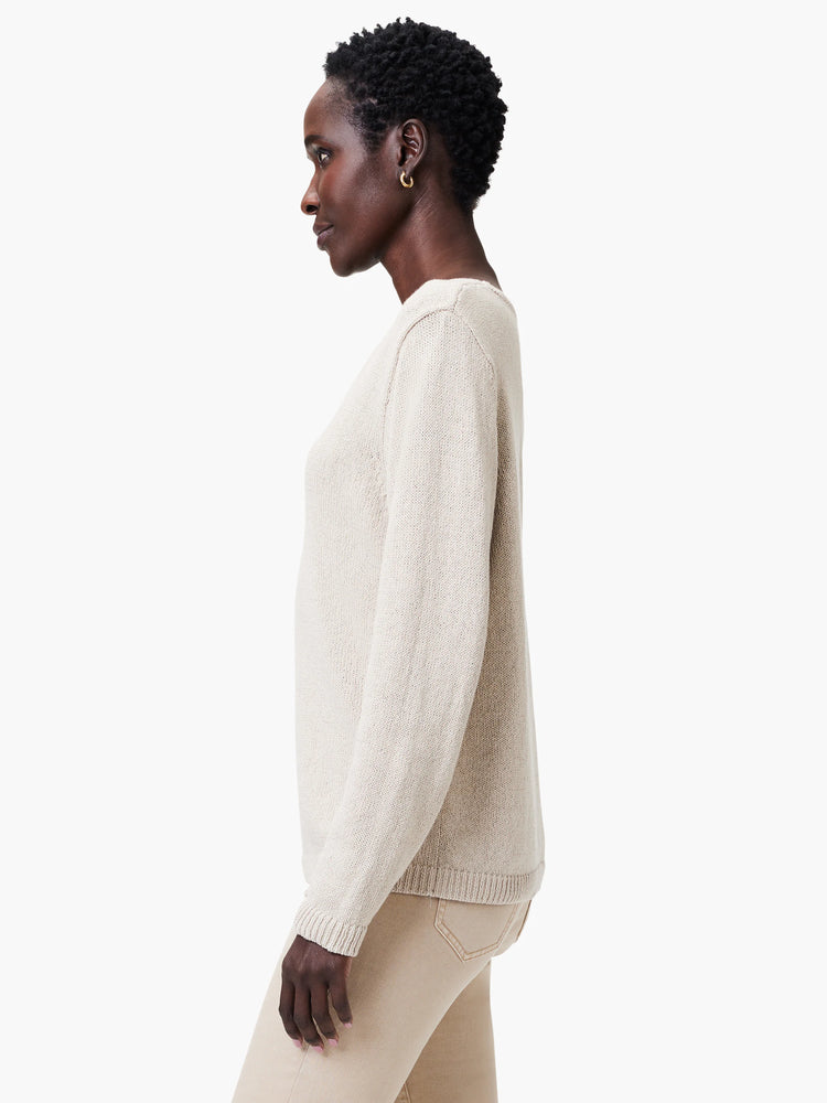 Light beige cotton cord V-neck sweater. Soft knit texture, long sleeves, ribbed cuffs and hem. Worn by model.
