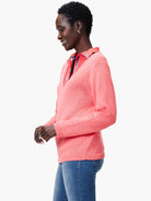 Coral pink knit V-neck sweater with visible collared shirt underneath. Features ribbed cuffs and hem.
