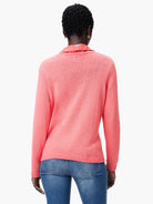 Coral pink corded knit sweater, seen from the back, with long sleeves and ribbed cuffs and hem.