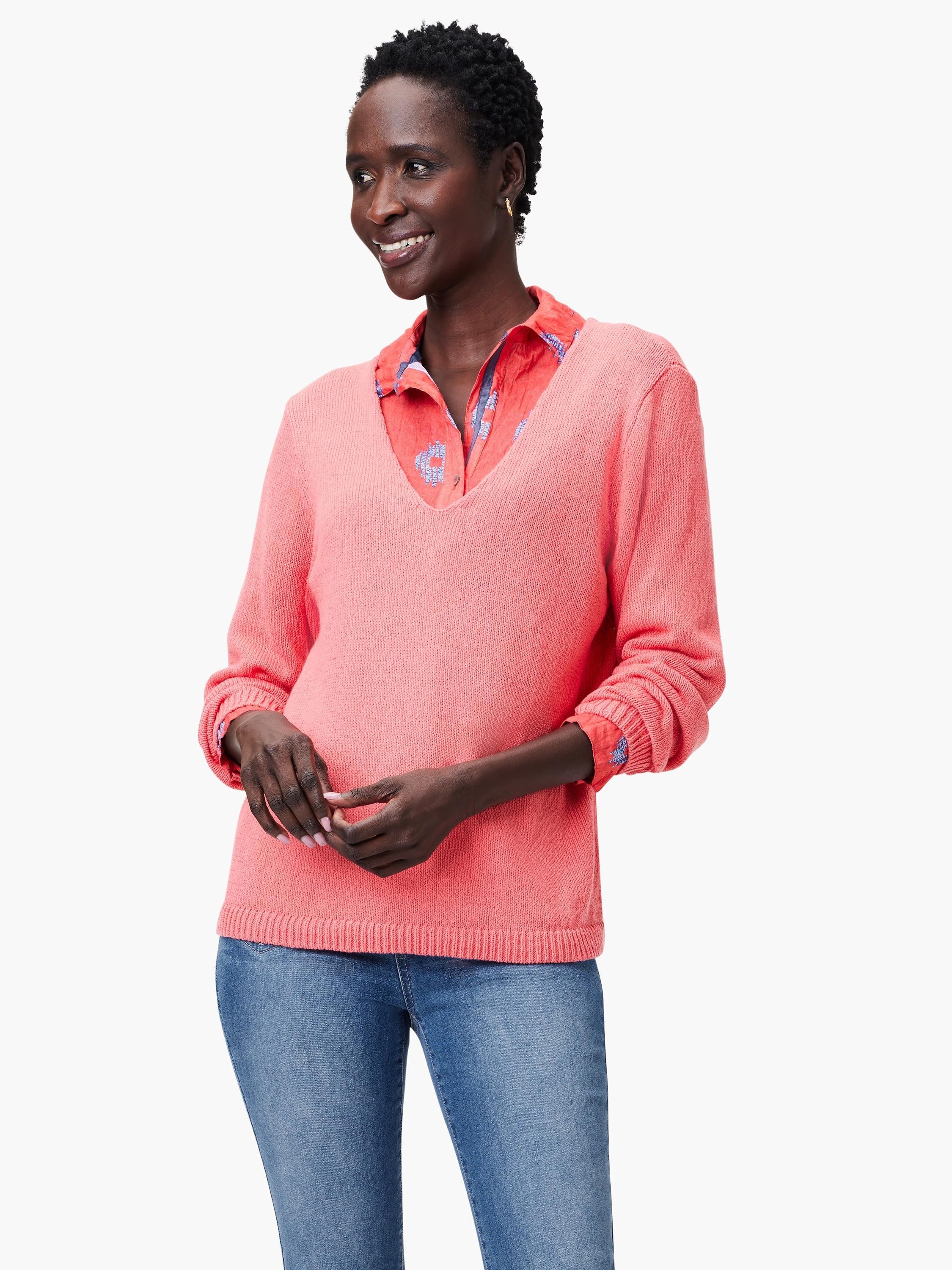Coral pink V-neck sweater with a soft knit texture, featuring ribbed cuffs and hem.