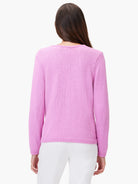 Back of a woman in a lilac long-sleeved knit sweater with ribbed cuffs and hem.