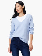 Pale blue V-neck sweater with a subtle corded knit texture and long sleeves.