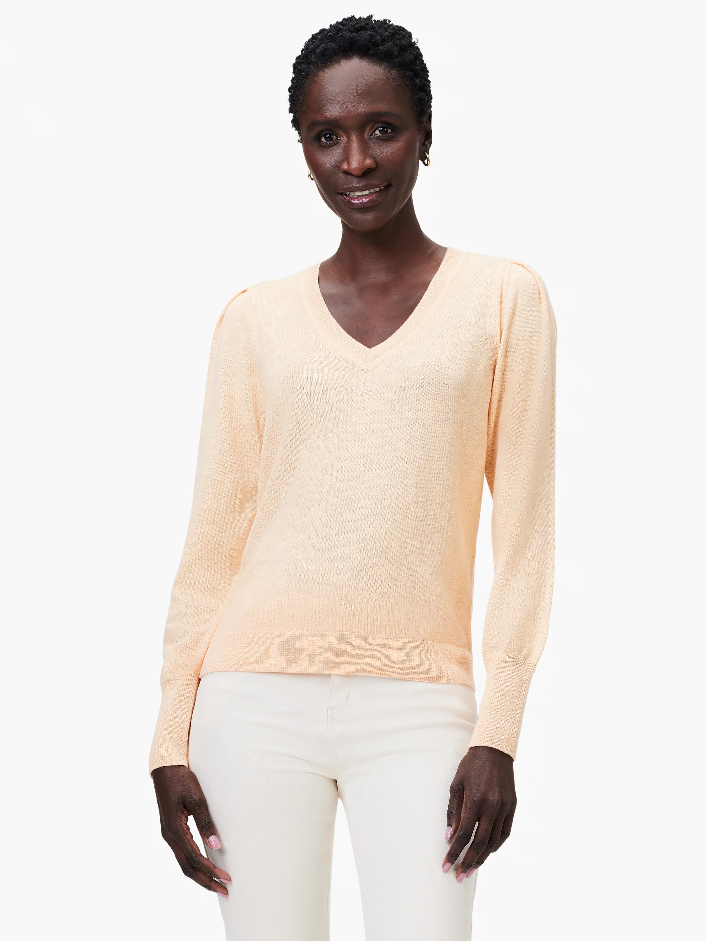 Peach-colored slub knit V-neck sweater with slightly puffed sleeves and long sleeves.