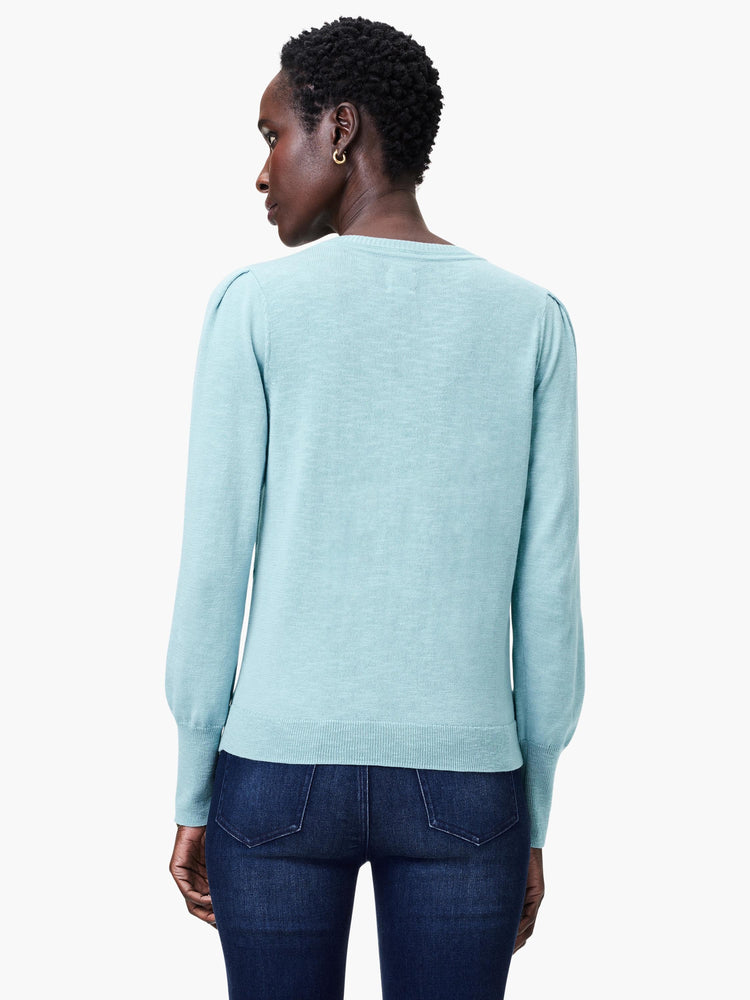 Light teal slub knit V-neck sweater; long sleeves with slightly puffed shoulders.  Back view.
