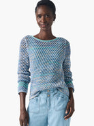 Crochet sweater; light blue, teal, and white; open-weave pattern; long sleeves; round neckline.