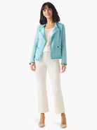 Light blue textured jacket with fringe on lapels, hem, and cuffs, featuring two front flap pockets.