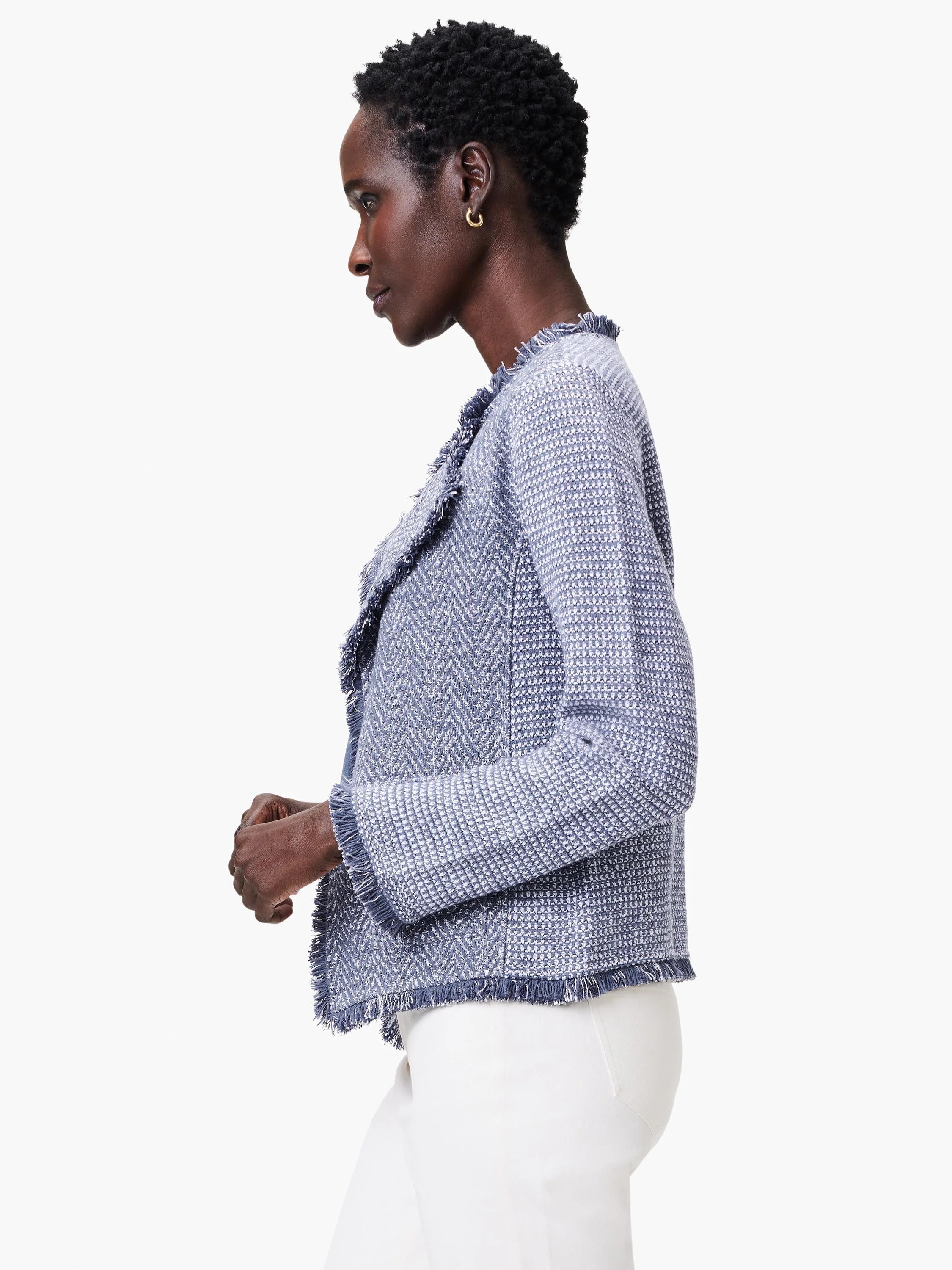 Periwinkle and white tweed jacket with fringe trim along the neckline, cuffs, and hem.