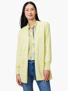 Pale yellow open cardigan with long sleeves and two pockets.  Shown on a model.