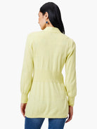 Pale yellow cardigan, long sleeves, fitted waist.  Back view.