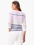 White sweater with horizontal stripes in lavender, gray, beige, and red. Three-quarter sleeves.