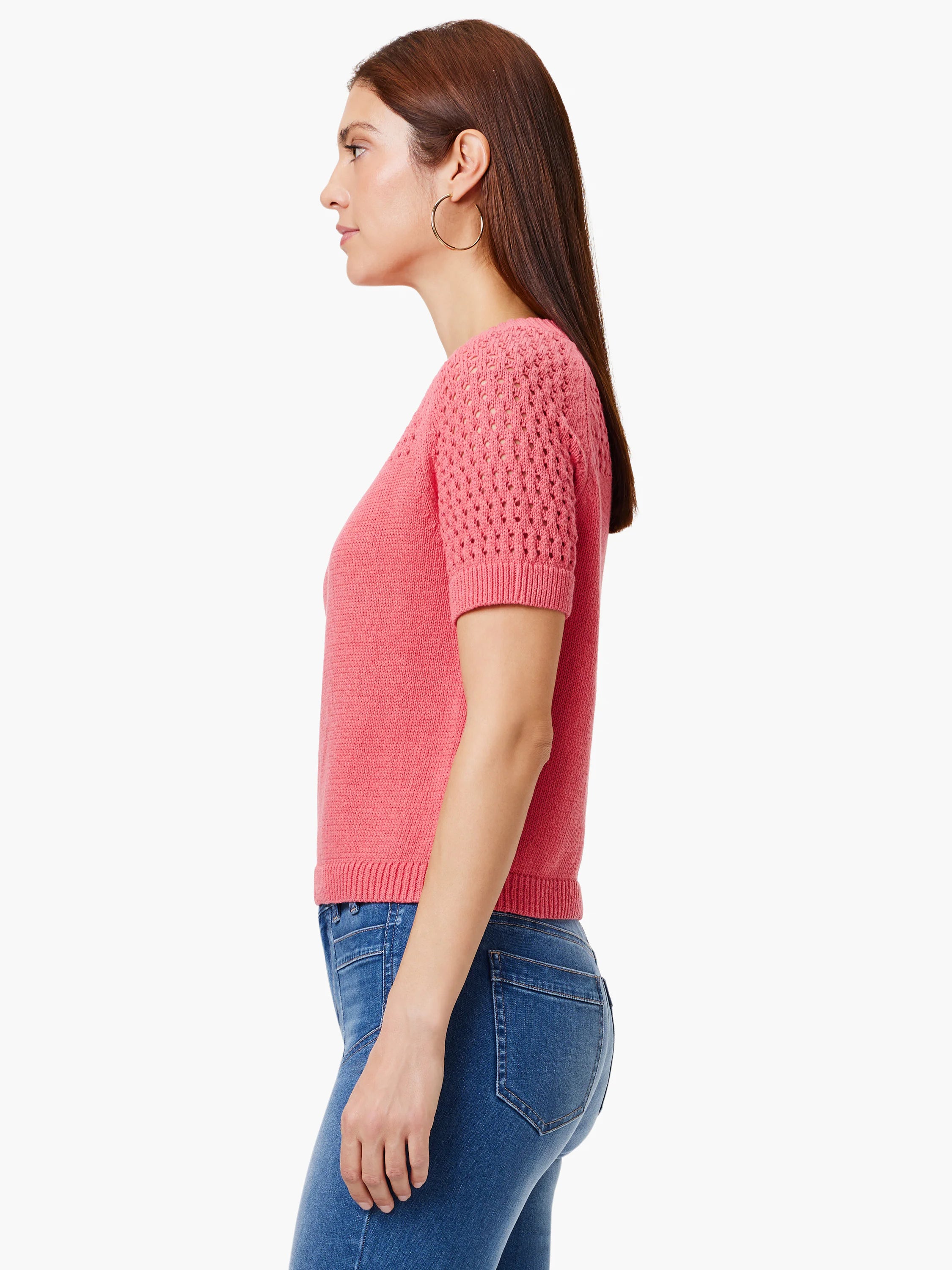 Pink crocheted short-sleeved sweater, featuring a textured yoke.  The sweater is shown on a model.