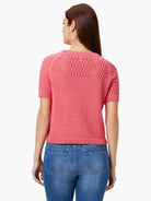 Pink crocheted sweater tee with short sleeves and open-weave detailing on the shoulders.  Back view.