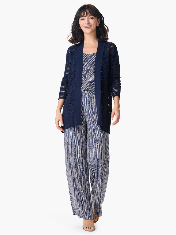 Navy blue open-front mesh cardigan, long sleeves.  Model also wears vertical navy/white striped pants.