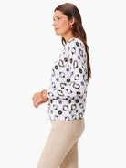 Off-white sweater with dark gray and black abstract spots.  Three-quarter sleeves.