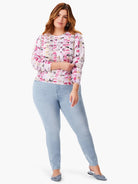 White sweater with pink, gray, and beige geometric mosaic pattern. Long sleeves.