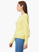 Light yellow sweater with voluminous sleeves, ribbed cuffs and hem. Model faces left.