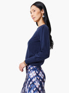 Navy blue sweater with a round neck and full sleeves gathered at the shoulders and cuffs.