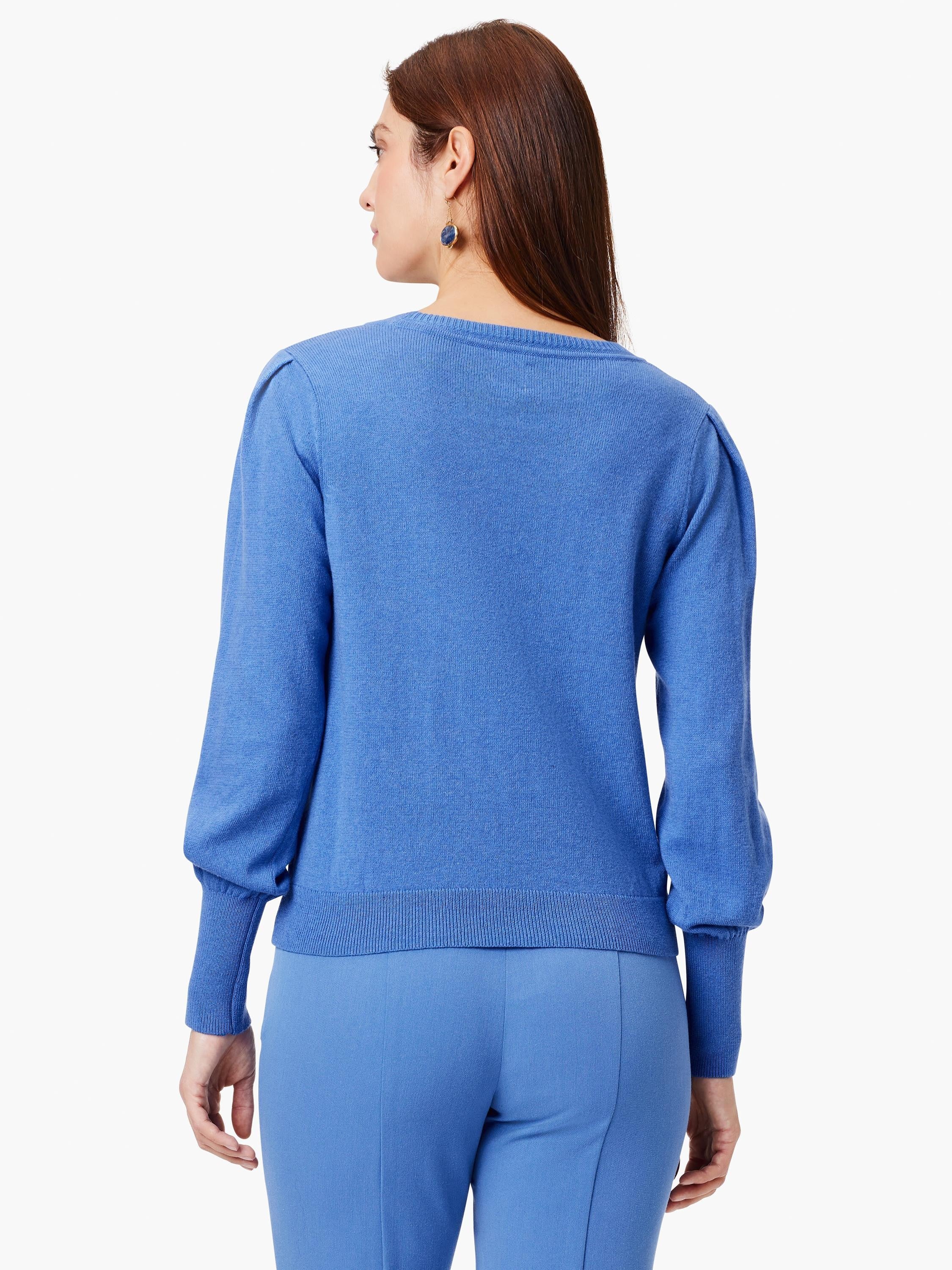 Blue knit sweater with crewneck, puffed long sleeves, and ribbed cuffs, seen from the back.