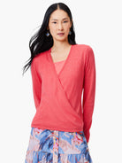 Coral pink wrap cardigan with long sleeves and V-neck. Fine knit fabric.