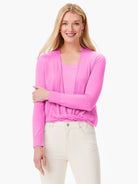 Bright pink long-sleeved cardigan, tied at the front, worn over a matching top.