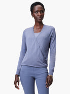 Periwinkle blue long-sleeve wrap cardigan with V-neck, styled as a top, features ribbed cuffs and hem.