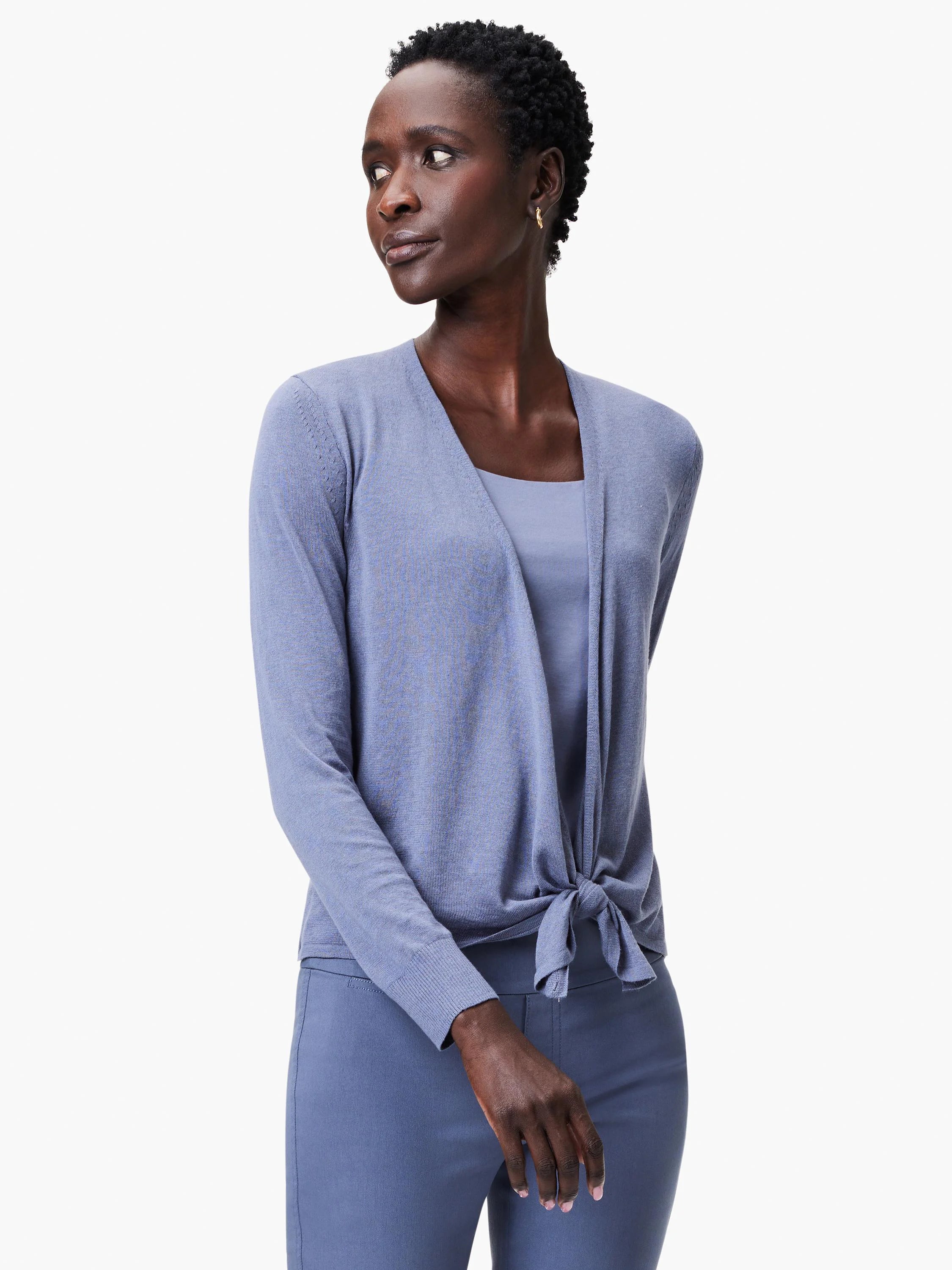 Periwinkle blue open cardigan with subtle sleeve texture, tied at front waist. Worn over matching tank top and darker pants.