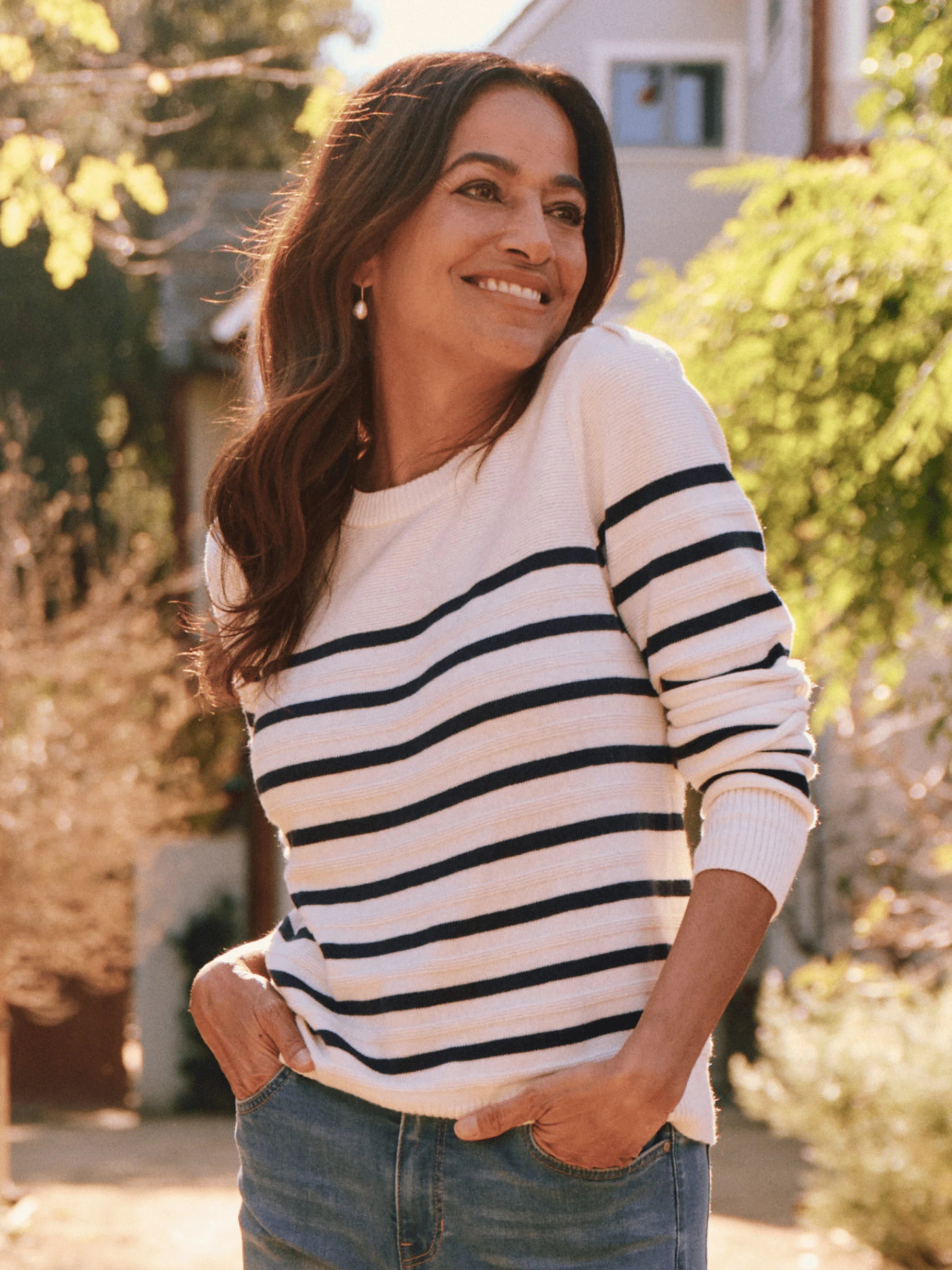 Cream cashmere sweater with navy blue horizontal stripes, long sleeves, and a round neckline.