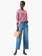 Pink cashmere sweater with navy stripes, long sleeves, and button accents.