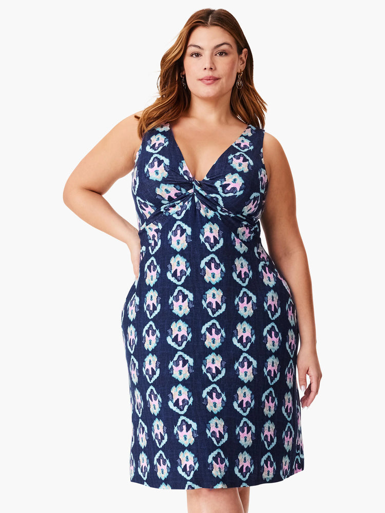 Navy sleeveless dress with a V-neck and knotted bodice. Features a repeating light blue, pink, and white ikat pattern. ...