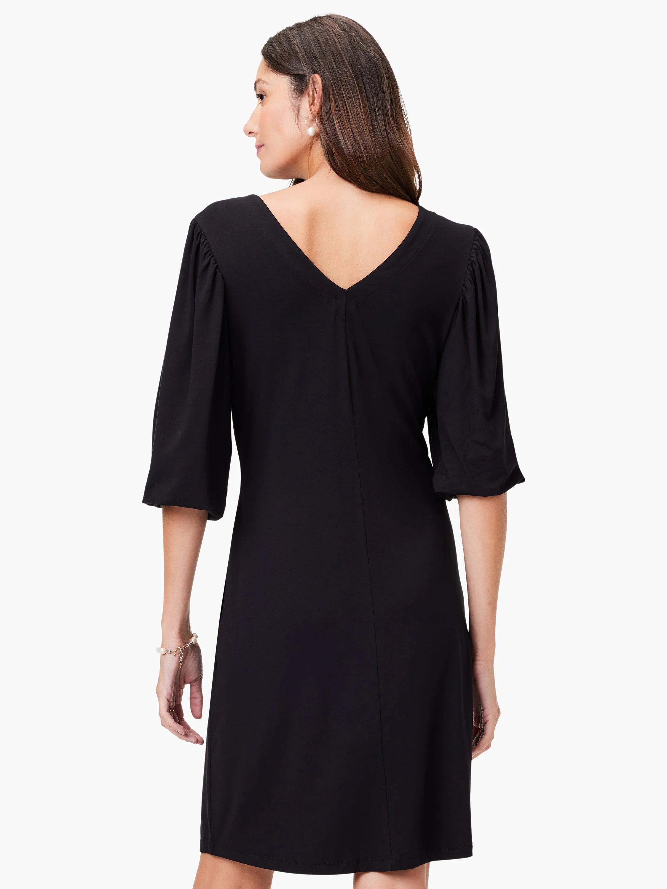 Black V-neck knit dress, elbow-length sleeves with slight puff at shoulder.  A-line silhouette.