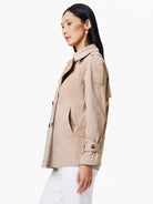 Beige trench coat; double-breasted, belted sleeves, and pockets.