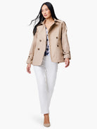 Beige double-breasted trench coat with belted cuffs.  Model shown wearing it.