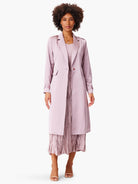 Lilac trench coat, knee-length, single button closure, long sleeves with tab detail.  Model shown wearing with pleated...