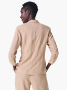 Beige jacket with thin pink and white vertical stripes, three-quarter sleeves with gathered cuffs, seen from the back.