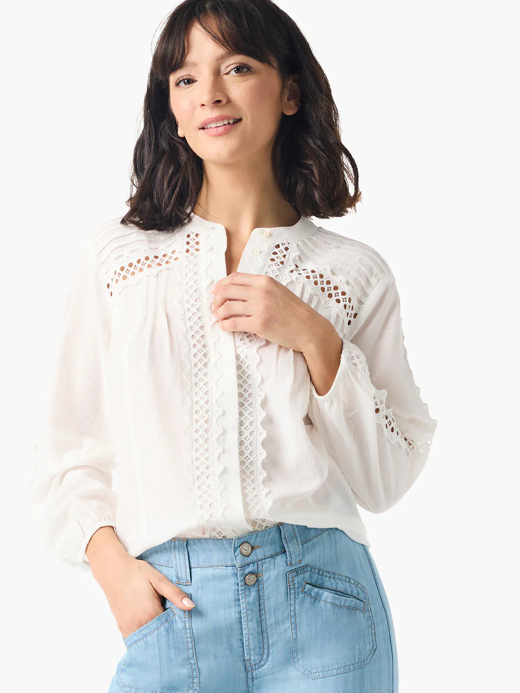 Off-white blouse with white eyelet embroidery along the front placket and sleeves.  Long sleeves, button front.