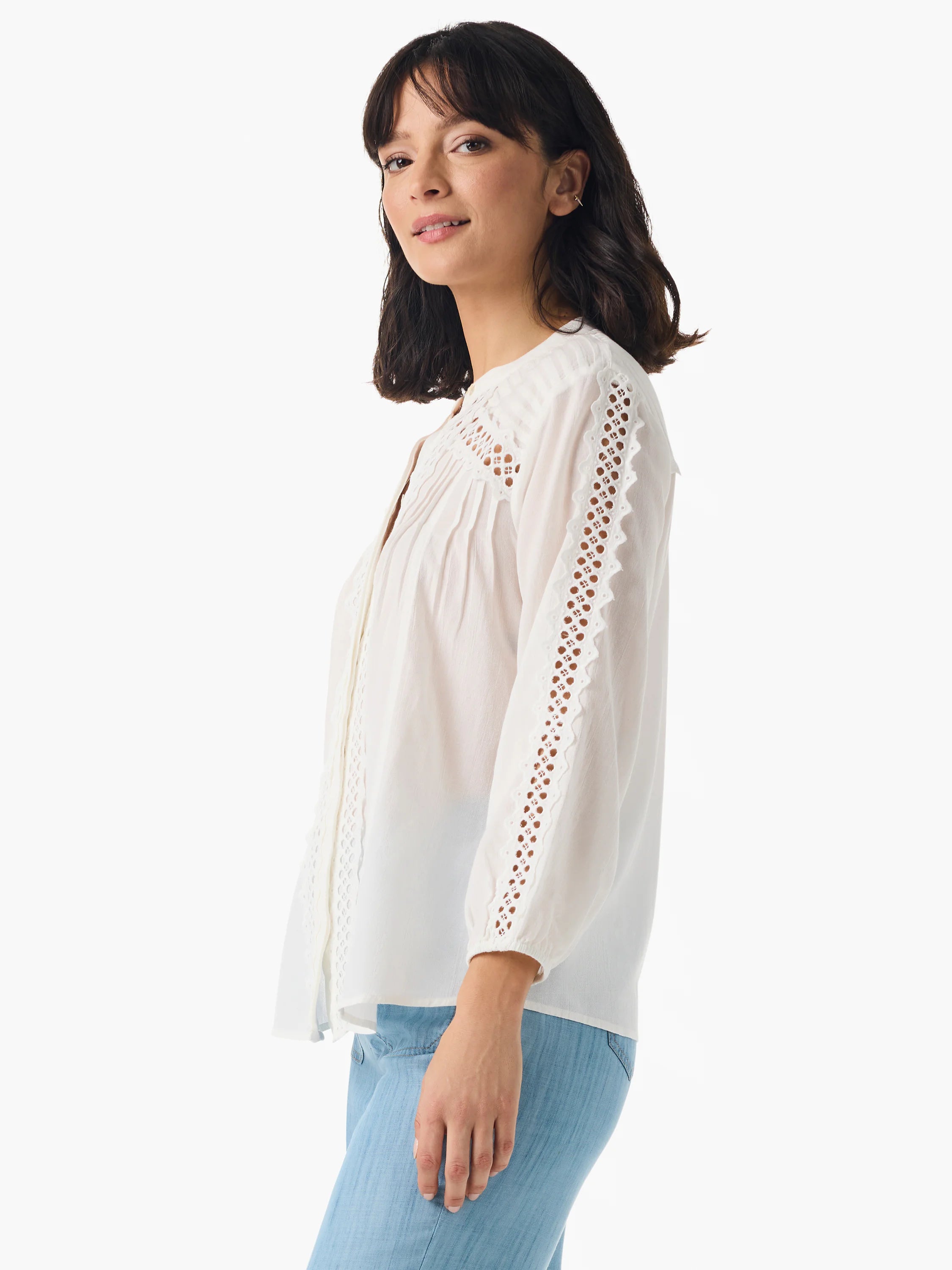 Off-white shirt with eyelet lace detailing at the neckline and sleeves. Three-quarter sleeves.